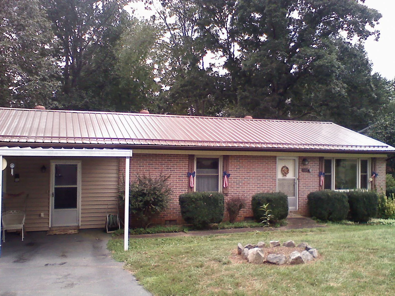 Bronze metal roof and carport on a brick ranch home — Roof Repair work by our crew in Burlington